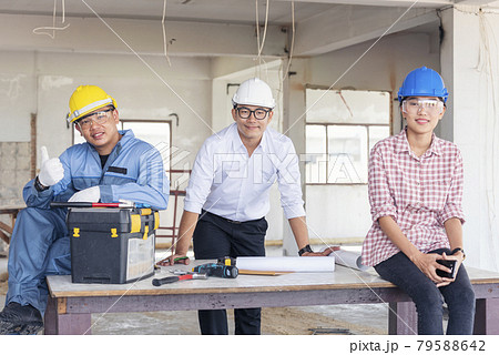 Construction engineer teamwork Safety Suit Trust Team Holding White Yellow Safety hard hat Security Equipment on Construction Site. Hardhat Protect Head for Civil Construction Engineer Concept 79588642