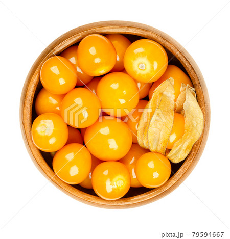 Cape gooseberries in a wooden bowl. Fresh fruits of Physalis peruviana, also known as golden, inca and ground berry, uchuva, poha, and rasbhari. Used as a garnish, a snack or as a dessert. Food photo. 79594667