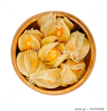 Cape gooseberries with partly open calyx, in a wooden bowl. Fresh fruits of Physalis peruviana, also golden, inca and ground berry, uchuva, poha, and rasbhari. Used as a garnish or dessert. Food photo 79594668