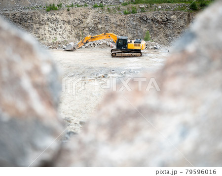 Heavy excavator working on earthmoving at open granite mine. Heavy excavator working on earthmoving at open granite mine. 79596016