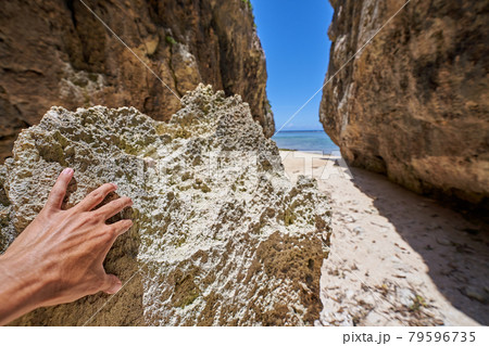 備瀬のワルミ 沖縄の自然が作った神秘的な風景 パワーストーンを触る男性の手 79596735
