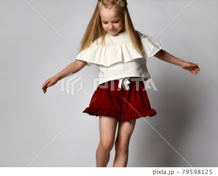 blonde girl dances and whirls on a white 79598125