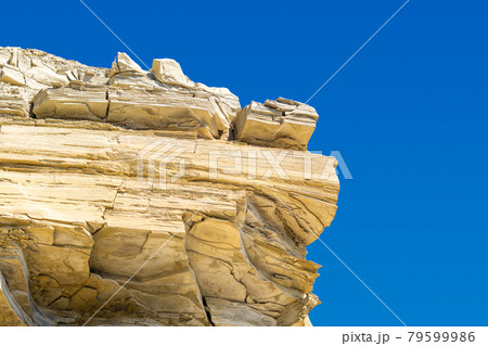 layered limestone cliff against blue sky layered limestone cliff against blue sky 79599986