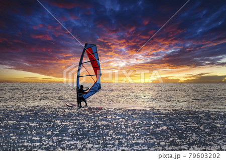 【夕日に向かって走るウィンドサーフィン　空合成】 79603202