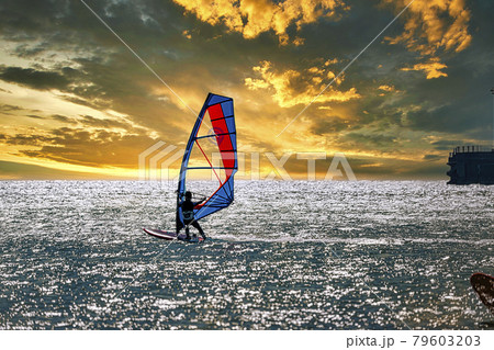 【夕日に向かって走るウィンドサーフィン　空合成】 79603203
