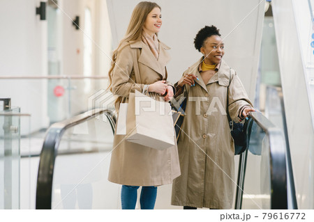Happy mixed girls walking the store with shopping bags 79616772
