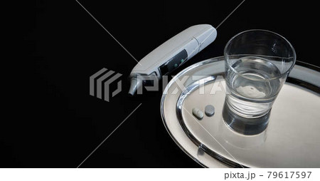Tabettes, water, clinical thermometer, black background: concept for febrile infections, for example by corona virus 79617597