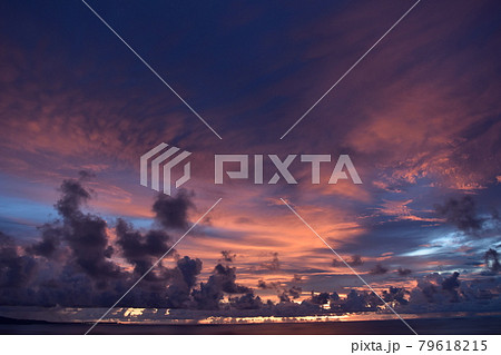 グラデーションの綺麗な夕日と海 地平線の背景素材 夏の旅行の思い出イメージの写真素材