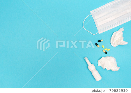 Seasonal spring allergy. Flat lay with nasal spray, pills, used wipes, and medical mask. Catch a cold. Template for text 79622930
