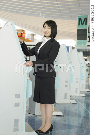 空港のチェックイン機を操作する女性 79625013