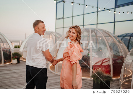 a man and a woman in love walk to a rooftop cafe on a date. a man and a woman in love walk to a rooftop cafe on a date. 79627026