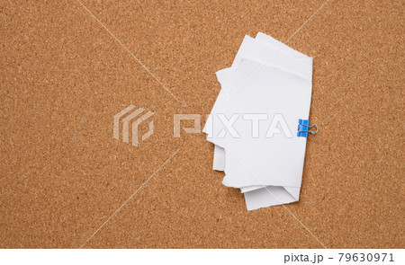 white blank paper sheets bound with a clip on brown background 79630971