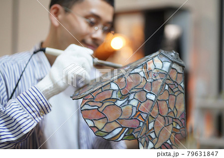 ステンドグラスのランプを作る男性 ステンドグラスのランプを作る男性 79631847