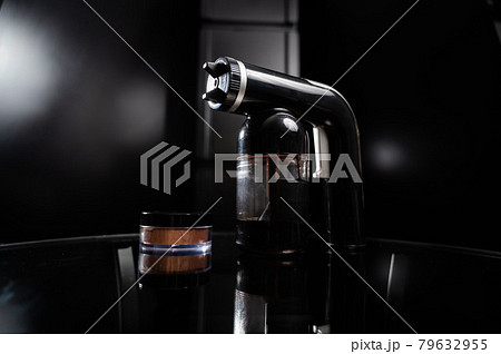 A close-up of the instant tanning equipment. Gun spraying paint for leather and matting body powder on a black background 79632955