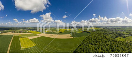 Panoramic aerial view over giant wind power field in Germany during daytime Panoramic aerial view over giant wind power field in Germany during daytime 79635347