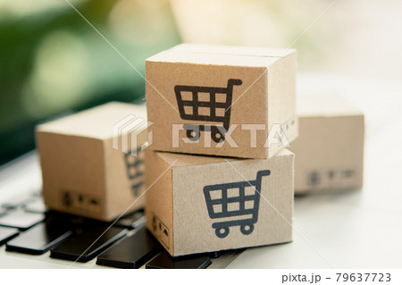 Shopping online. Cardboard box with a shopping cart logo on laptop keyboard. Shopping service on The online web. offers home delivery. copy space. Shopping online. Cardboard box with a shopping cart logo on laptop keyboard. Shopping service on The online web. offers home delivery. copy space. 79637723