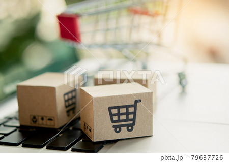 Shopping online. Cardboard box with a shopping cart logo on laptop keyboard. Shopping service on The online web. offers home delivery. copy space. 79637726