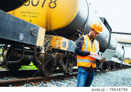 Inspector Engineering wearing helmet and vest worker unifrom checking railway construction work on rail track. Asian worker working on a laptop consulting with a partner Inspector Engineering wearing helmet and vest worker unifrom checking railway construction work on rail track. Asian worker working on a laptop consulting with a partner 79638796