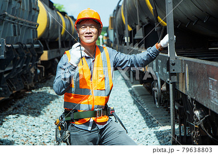 Inspector Engineering wearing helmet and vest worker unifrom checking railway construction work on rail track. Asian workers are using a walkie talkie to coordinate. Inspector Engineering wearing helmet and vest worker unifrom checking railway construction work on rail track. Asian workers are using a walkie talkie to coordinate. 79638803