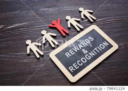 Plate with Rewards and recognition words and wooden employee figures. 79641124