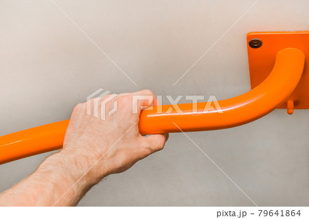 Man's hand holding a metal handrail in the toilet Man's hand holding a metal handrail in the toilet 79641864