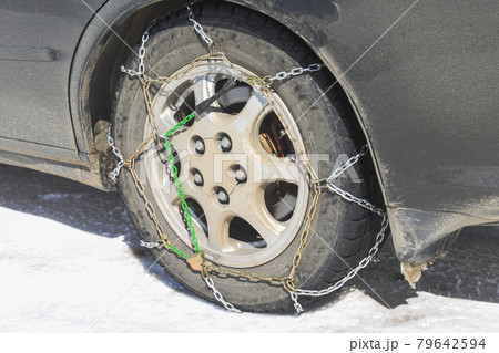 Close-up of snow chains on tires on a winter road Close-up of snow chains on tires on a winter road 79642594