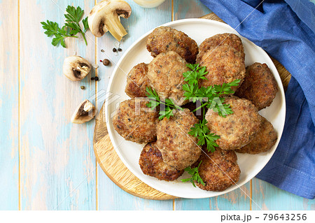 Homemade meatballs with mushrooms on the kitchen wooden table. Top view of a flat lay. Copy space. Homemade meatballs with mushrooms on the kitchen wooden table. Top view of a flat lay. Copy space. 79643256
