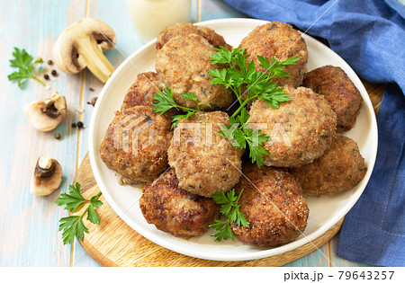 Homemade meatballs with mushrooms on the kitchen wooden table. Homemade meatballs with mushrooms on the kitchen wooden table. 79643257