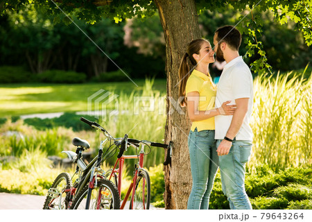 Young couple is kissing on summer nature background. Young couple is kissing on summer nature background. 79643264