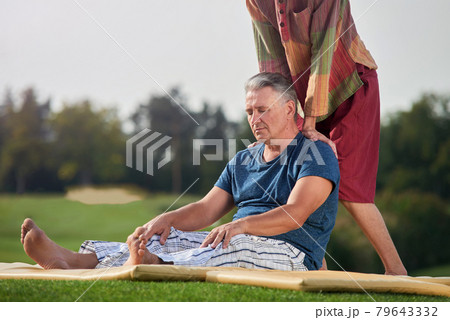 Massaging of a sitting man on the mat. Massaging of a sitting man on the mat. 79643332