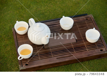 White tea pot and tea cups. 79643348