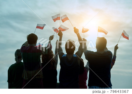 Poland patriotic people with small flags, back view. 79643367