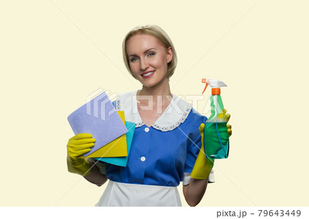 Housekeeper in uniform holding cleaning supplies. Housekeeper in uniform holding cleaning supplies. 79643449
