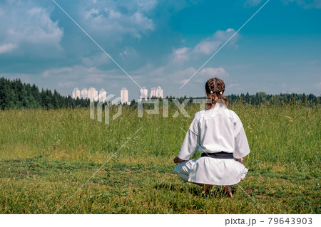 teenage girl karateka before starting training outdoor enters the mokuso meditative state in the seiza pose teenage girl karateka before starting training outdoor enters the mokuso meditative state in the seiza pose 79643903