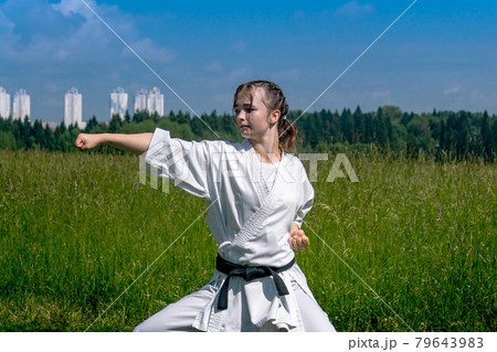 teen girl practicing karate kata outdoors in kiba-dachi stance 79643983