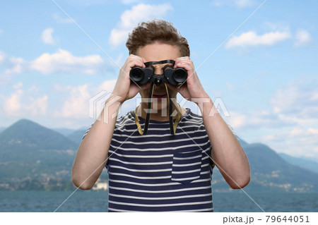 Teen boy looking through binoculars outdoor. Teen boy looking through binoculars outdoor. 79644051