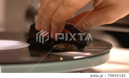 Close-up view of hand which holding a gramophone's needle. 79644192