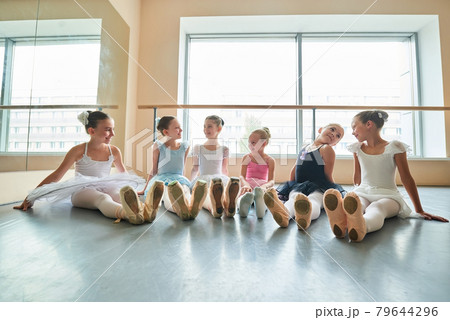 Happy young ballerinas sitting on the floor. 79644296