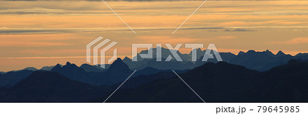 Bright lit yellow morning sky over Mount Grosser Mythen, Saentis and other mountains in the Swiss Alps. 79645985