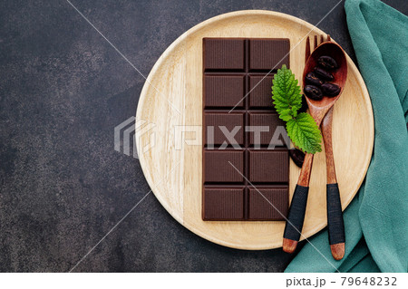 Food conceptual image with dark chocolate and fork on dark concrete background. Food conceptual image with dark chocolate and fork on dark concrete background. 79648232