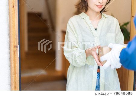 デリバリーを受け取る若い女性 79649099