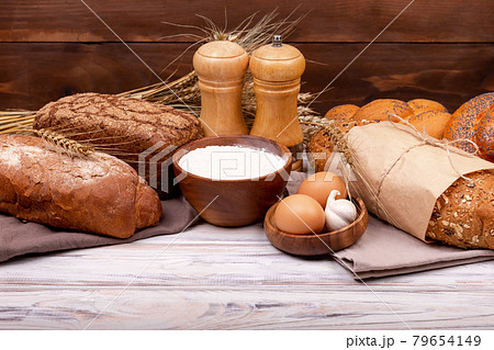Collection of grain bread and baked goods on wooden background. Collection of grain bread and baked goods on wooden background. 79654149