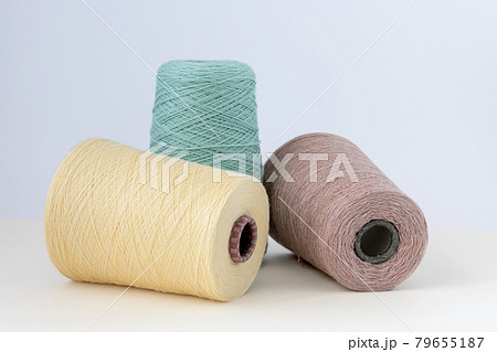 Pastel color bobbins of wool yarn for hand and machine knitting on a white background 79655187