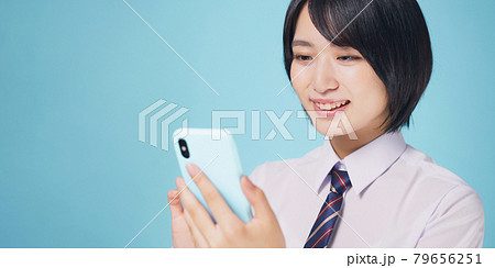 スマホを見て笑顔になる女性 女子高生 スマホを見て笑顔になる女性 女子高生 79656251