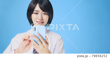 スマホを見て笑顔になる女性　女子学生 79656252