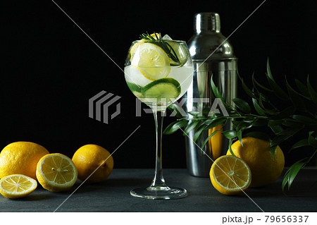 Glass of cocktail with citrus against dark background 79656337