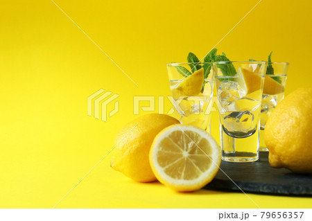 Shots with lemon slice and mint on tray on yellow background Shots with lemon slice and mint on tray on yellow background 79656357