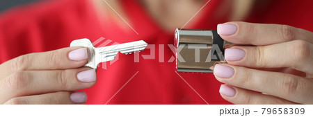 Female hands hold key and lock closeup Female hands hold key and lock closeup 79658309