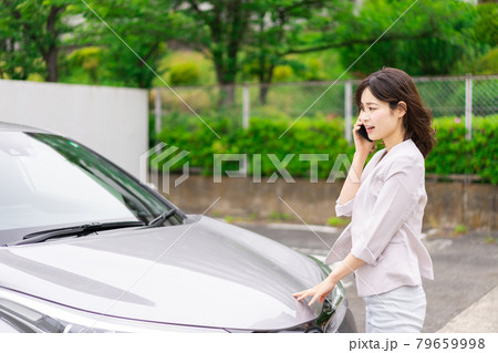 車が故障して連絡をする若い女性 車が故障して連絡をする若い女性 79659998