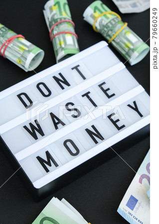 Lightbox board with word DONT WASTE MONEY in black letters around euro banknotes. Money, Business, finance, investment, saving Lightbox board with word DONT WASTE MONEY in black letters around euro banknotes. Money, Business, finance, investment, saving 79660249